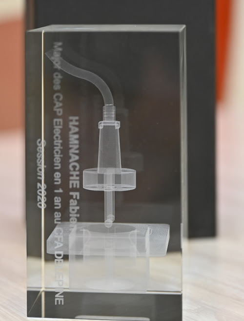 Trophée pour le major du CAP Electricien 1 an au CFA Delépine, plastique transparent, représentant une prise électrique.